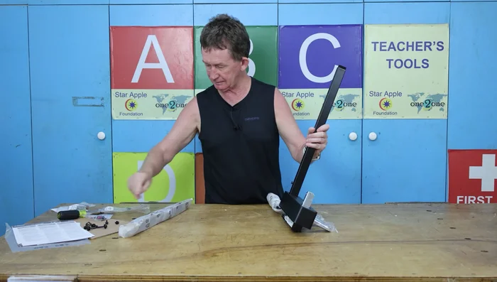 Attach the pedal unit to the pre-assembled legs using four longer screws and spring washers.