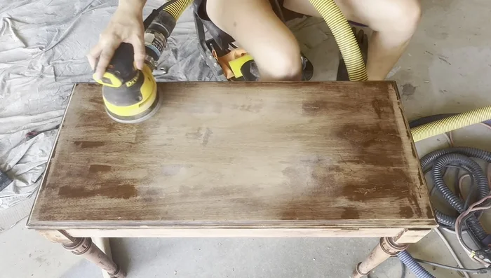 Sand the surface. Use 120 grit sandpaper on veneer, and 80 grit for other areas. Use sanding blocks and contoured pieces for detailed areas. Use a surf prep sander with foam abrasives for efficiency.