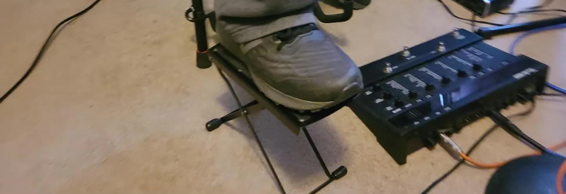 The presenter mentions using a cable box as a makeshift footrest