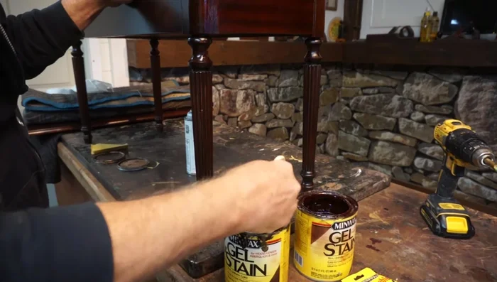 Apply a mixture of gel stains (in this case, coffee and mahogany) to match the original color, feathering it out to blend seamlessly with the surrounding wood.