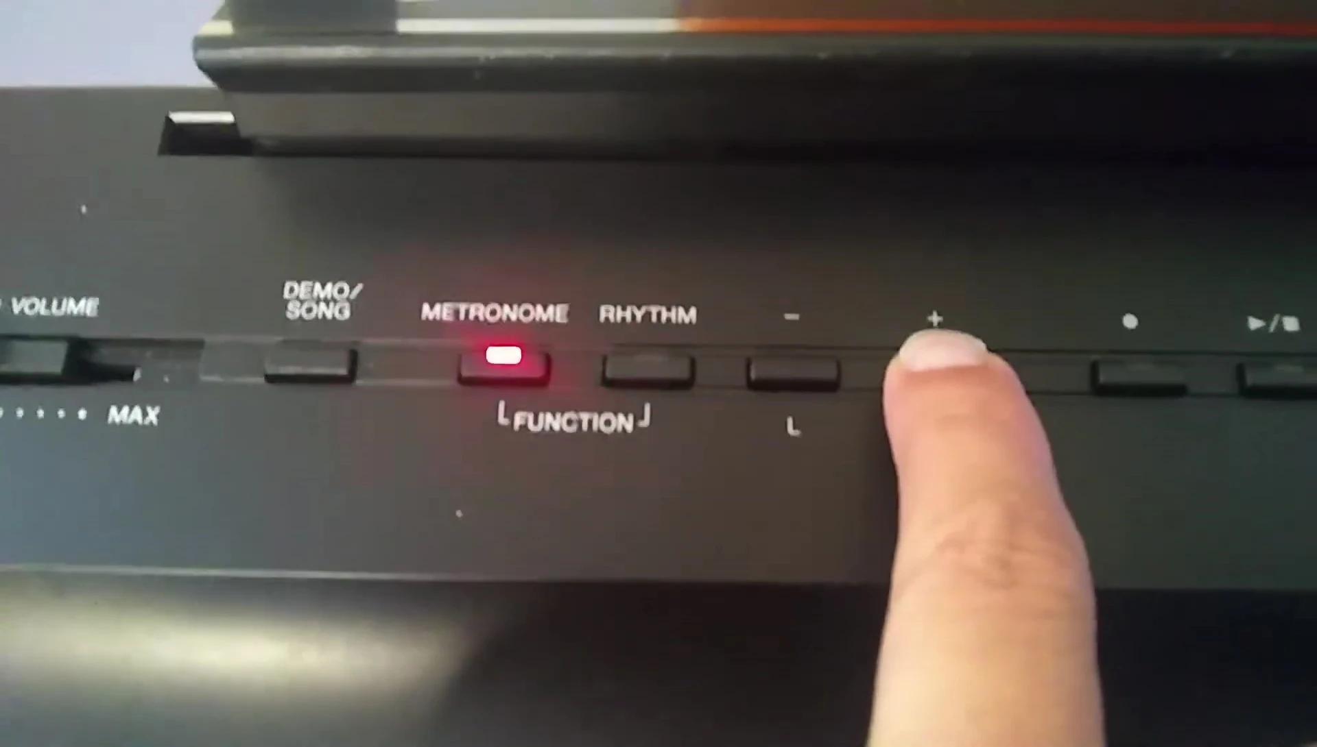 Close-up shot highlighting the plus and minus buttons for tempo adjustment.