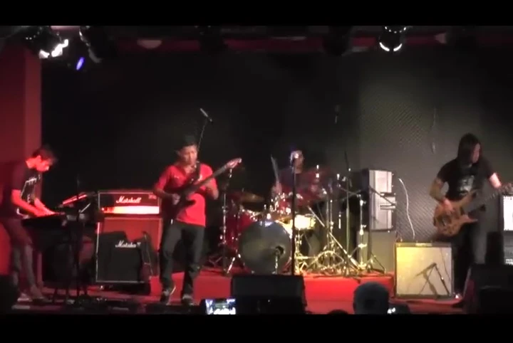 A wide shot of the band performing on stage