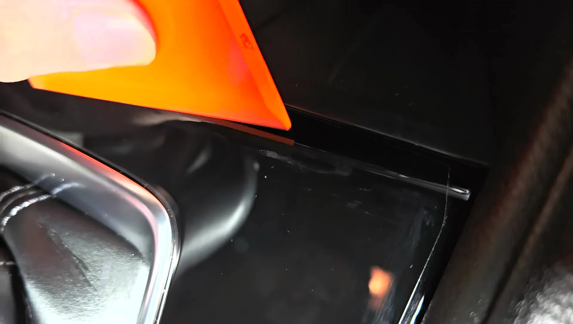 Using the squeegee to smooth out the film and remove air bubbles.