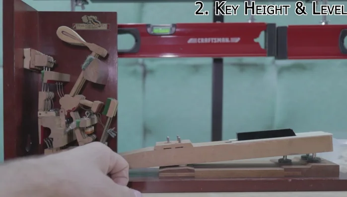 Key Height and Level: Adjust key height to approximately 64-65mm from the key bed to the underside of the key cap using paper punchings and felt. Ensure levelness across the keyboard using a straight piece of metal.