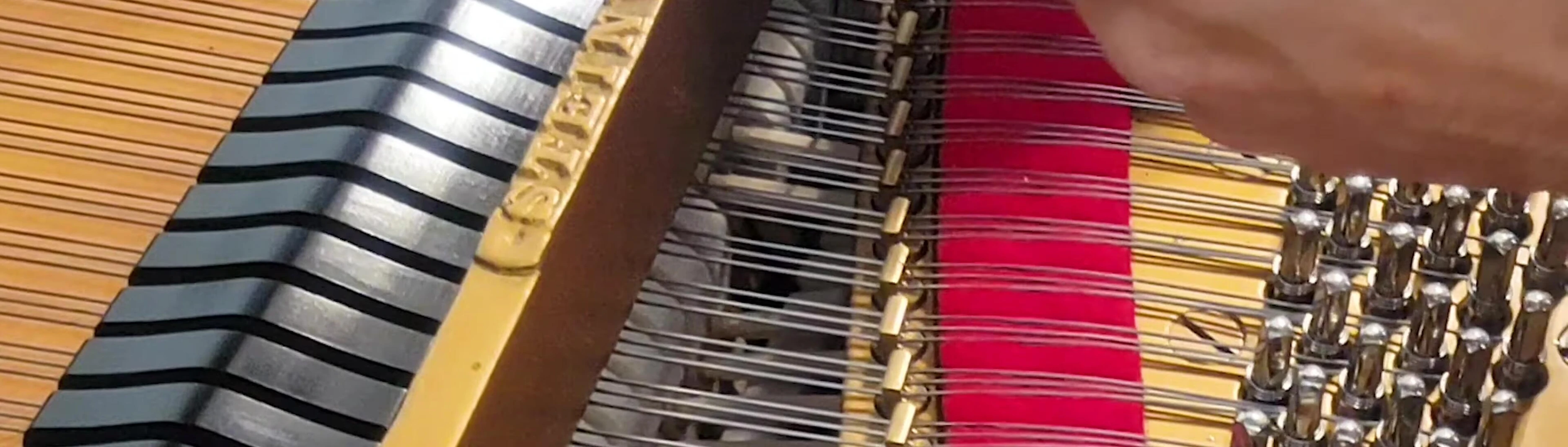 Technician adjusting the piano strings with a specialized tool