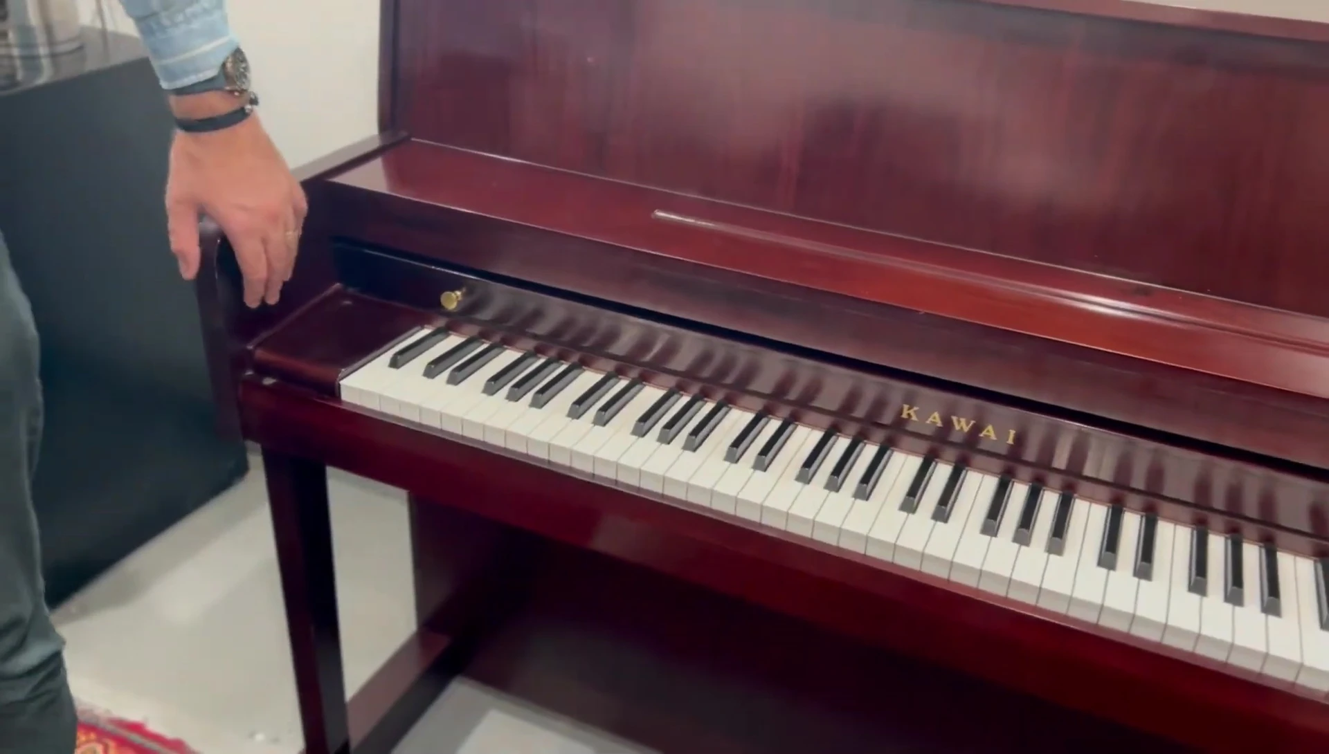 Close-up of the piano's dark cherry finish and music desk.