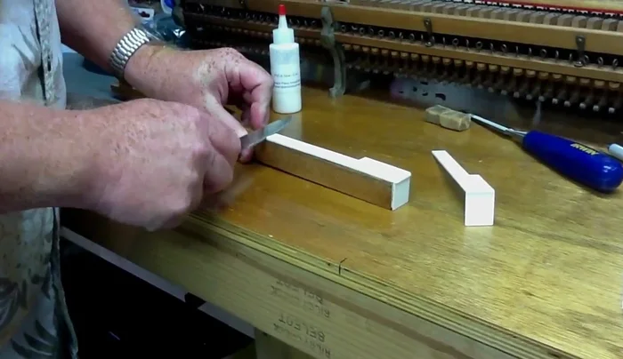 Sand the surface of the key to remove old glue and ensure a smooth, flat surface.