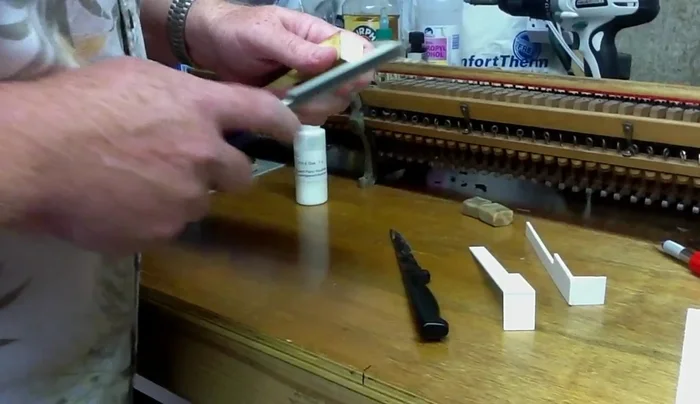 Sand the surface of the key to remove old glue and ensure a smooth, flat surface.