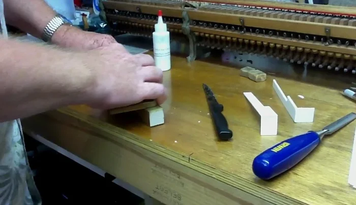 Sand the surface of the key to remove old glue and ensure a smooth, flat surface.