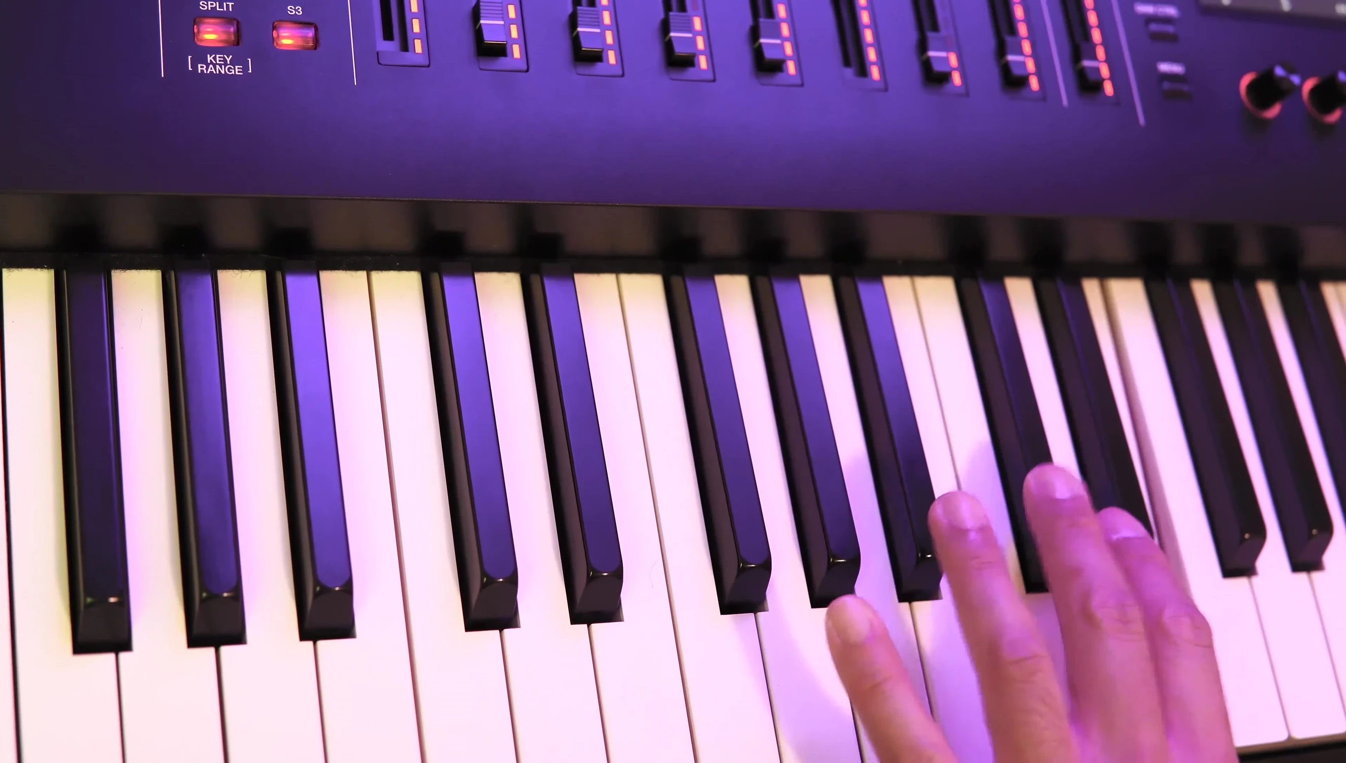 A wide shot of the performer's interaction with the keyboard and controls