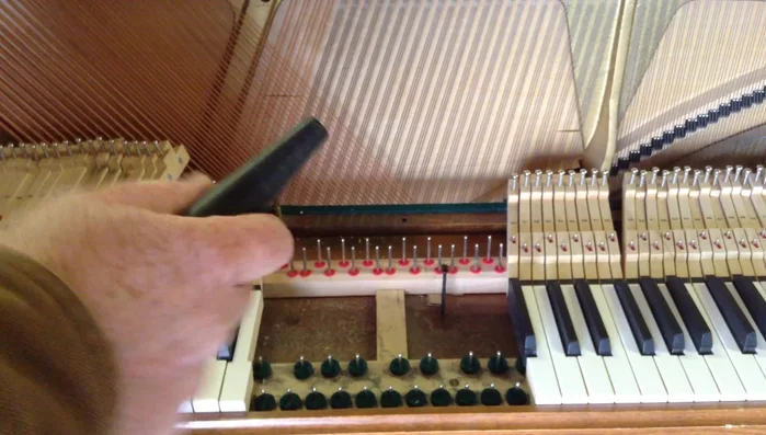 Clean under the keys and around the tuning pins: Use a vacuum cleaner with a small nozzle to remove dust and debris from under the keys and around the tuning pins. A brush attachment can help loosen stubborn dirt.