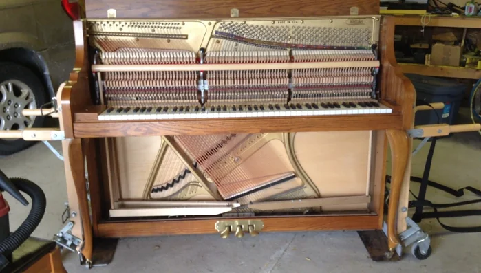 Access the piano's interior: Remove the music desk and fall board to expose the action, keys, and strings.