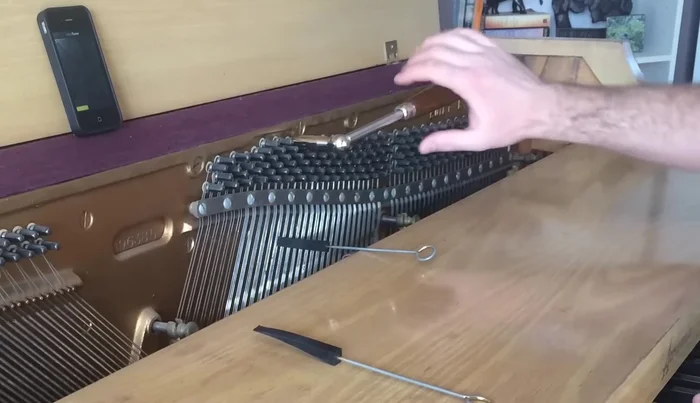 Tune the remaining strings of middle C by ear, aiming to eliminate the wavering sound by matching the pitch with the previously tuned string.