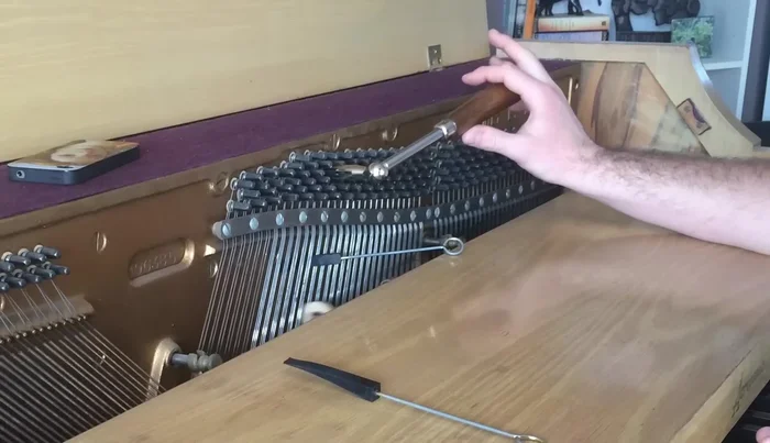 Tune the remaining strings of middle C by ear, aiming to eliminate the wavering sound by matching the pitch with the previously tuned string.