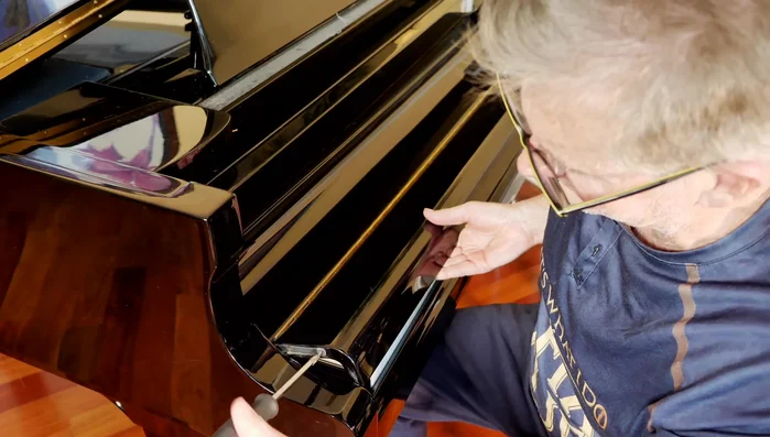 Carefully remove the keyboard cover, ensuring not to scratch the piano.