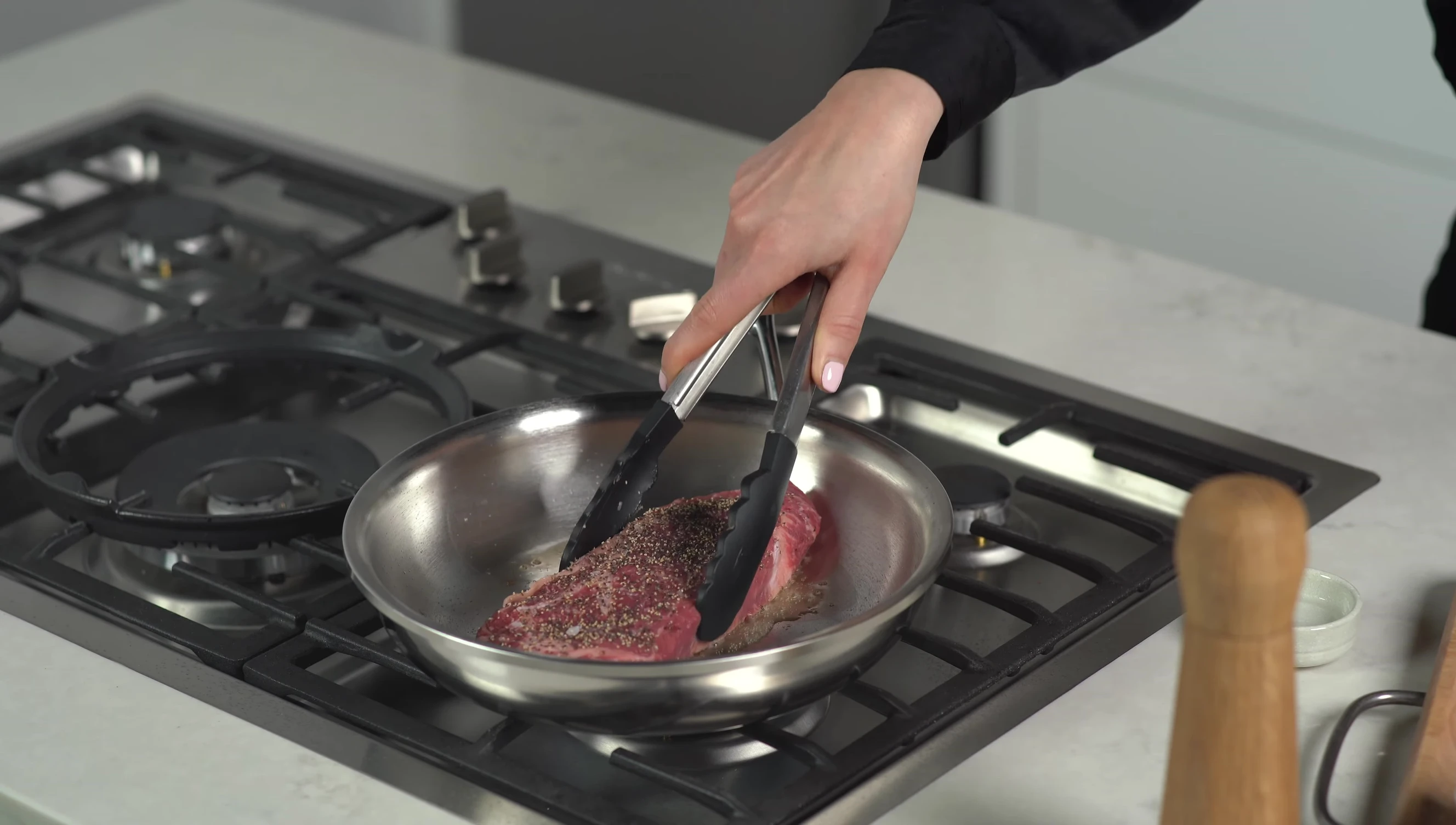 Steak sizzling in the pan, showcasing even browning
